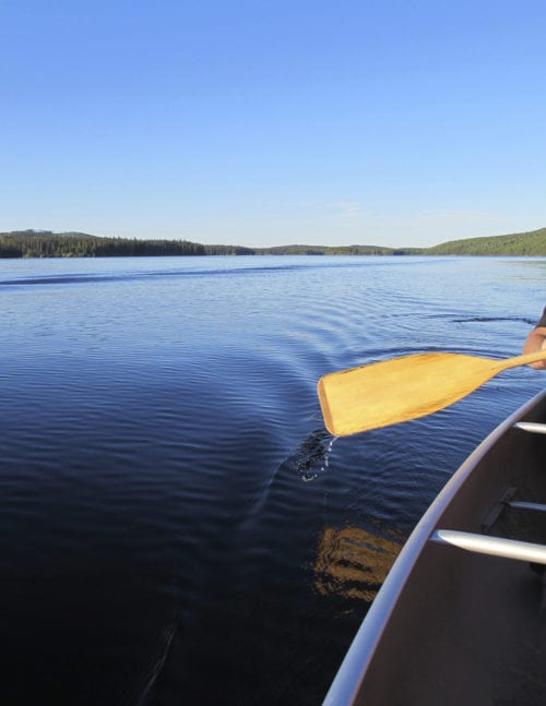 Canoe oar paddling boat through calm lake waters near Hartford, CT